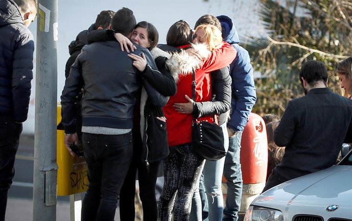 Familiares de las víctimas se abrazan en el lugar donde los equipos de emergencia han localizado este miércoles 1 de enero los cadáveres de dos jóvenes, un hombre y una mujer, sin aparentes signos de violencia, en el interior de un coche estacionado en Arrasate (Gipuzkoa). EFE/Javier Etxezarreta