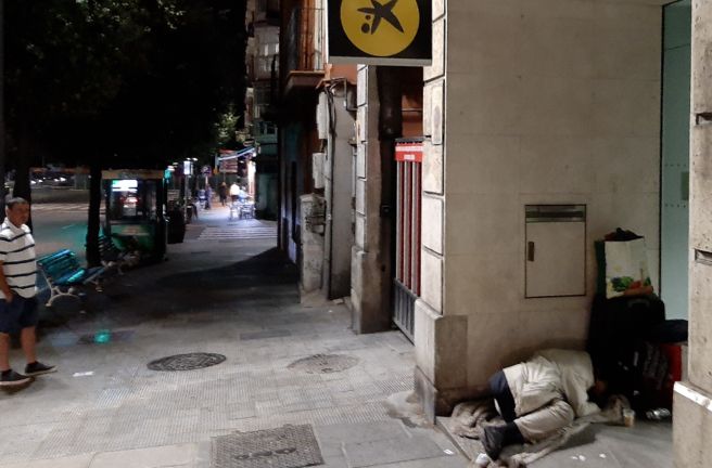 Una persona durmiendo en la entrada de un banco en Santander. / S. Díaz