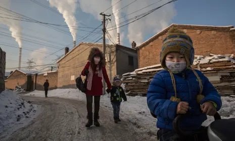 Los residentes de Shanxi usan máscaras para protegerse mientras el humo sale de las pilas de carbón en 2015. Fotografía: Kevin Frayer / Getty Images