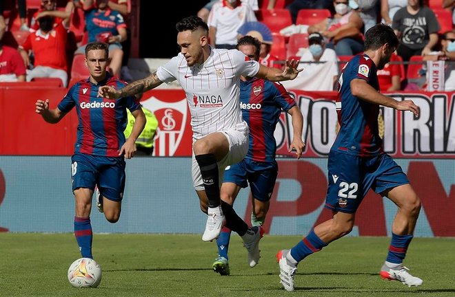 El jugador del Sevilla Ocampos y Melero del Levante luchan por el balón, durante el partido de LaLiga disputado este domingo en el estadio Sanchez Pizjuán de Sevilla. EFE/Jose Manuel Vidal.