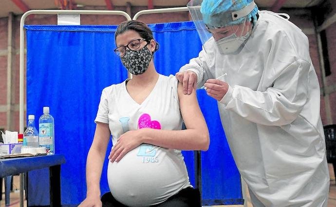 Una mujer embarazada recibe la vacuna contra el coronavirus. / AFP