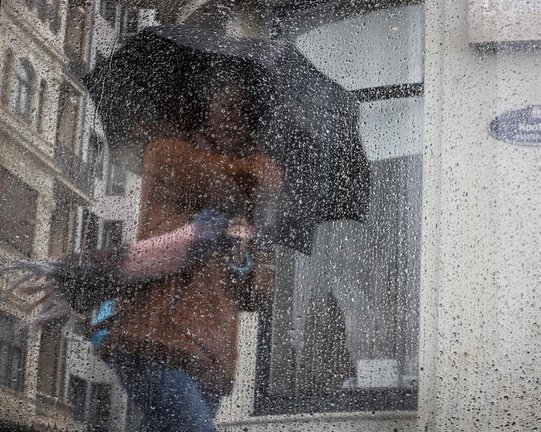 Una mujer camina bajo la lluvia este jueves en San Sebastián. Los cielos en el País Vasco estarán cubiertos con precipitaciones que serán muy abundantes y persistentes en la vertiente cantábrica, mientras que la cota de nieve se situará en torno a los mil metros. EFE/Javier Etxezarreta