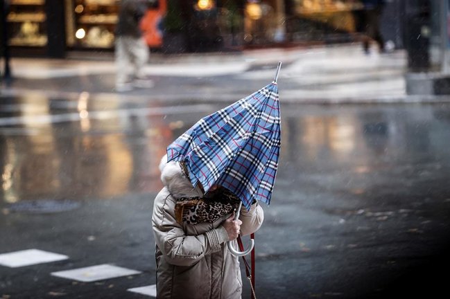Una mujer camina bajo la lluvia en San Sebastián. EFE/Javier Etxezarreta