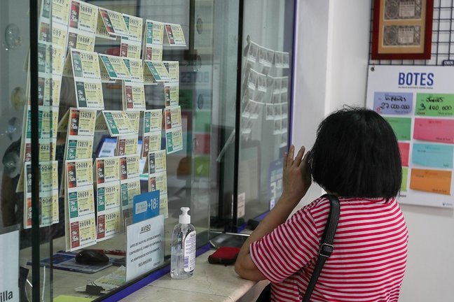 Una mujer compra lotería en una Administración.