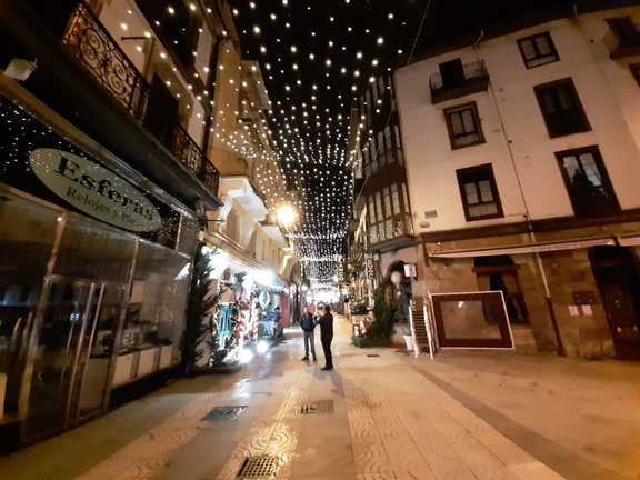 Dos personas se hacen una foto en la calle Consolación de Torrelavega con las luces navideñas. / ALERTA