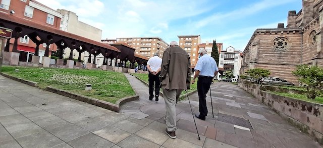 Varias personas de avanzada edad pasean por la plaza de la iglesia de Nuestra Señora de la Asunción en Torrelavega. / ALERTA