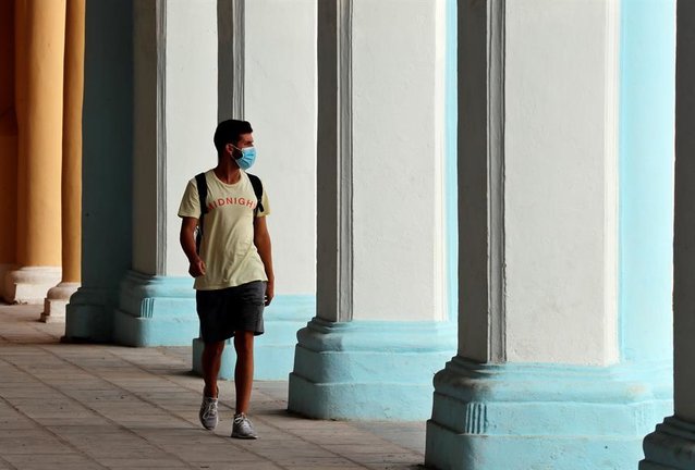 Un joven camina con mascarilla por unos portales en La Habana Vieja (Cuba). EFE/ Ernesto Mastrascusa/Archivo