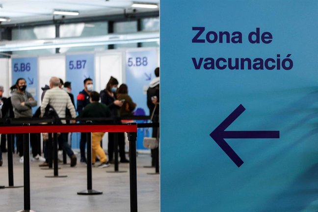 Decenas de ciudadanos guardan su turno en cola para accecer al centro de vacunación instalado en la Fira de Barcelona, en una fotografía de archivo. EFE/Quique Garcia