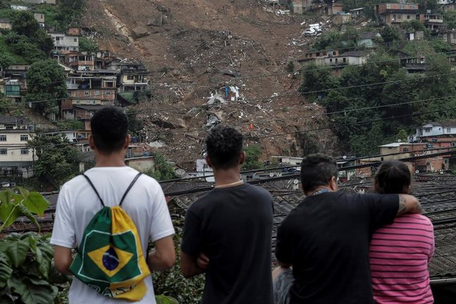 Varias personas observan la destrucción tras las fuertes lluvias del martes en el Morro de la Oficina, hoy, en la ciudad de Petrópolis, estado de Rio de Janeiro (Brasil). EFE/ Antonio Lacerda