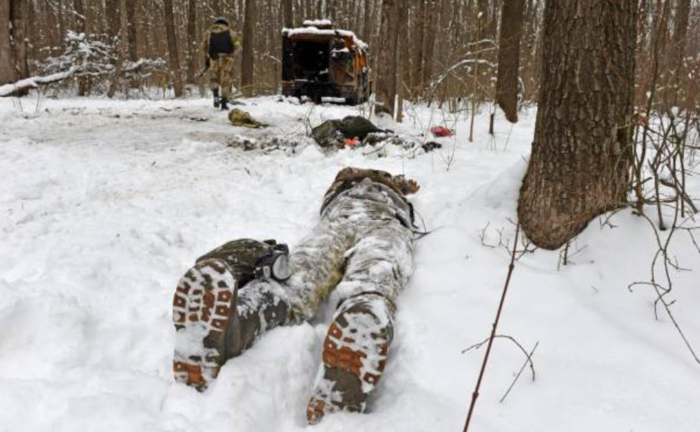 na fotografía tomada el 7 de marzo de 2022 muestra el cadáver de un militar cerca de un vehículo militar ruso destruido en un bosque a las afueras de la segunda ciudad más grande de Ucrania, Kharkiv. Sergey BOBOK / AFP