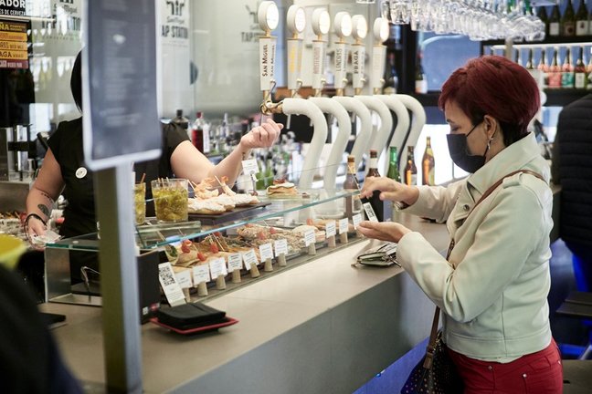 Una mujer paga su consumición en el interior de un bar, a 1 de octubre de 2021, en Pamplona, Navarra (España)