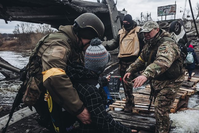 Cargar máis
Unos soldados ayudan a cruzar el río a un niño, a 7 de marzo de 2022, en Irpin (Ucrania).