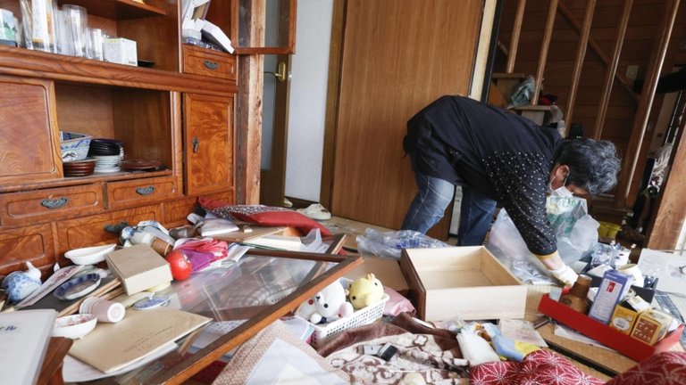 Una mujer limpia su casa en Kunimi, prefectura de Fukushima, el jueves después de que un poderoso terremoto sacudiera la región de Tohoku la noche anterior.  |  KYODO
