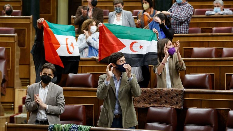 Diputados de Unidas Podemos ondean banderas saharauis durante el pleno que se celebra este martes en el Congreso. EFE/MARISCAL