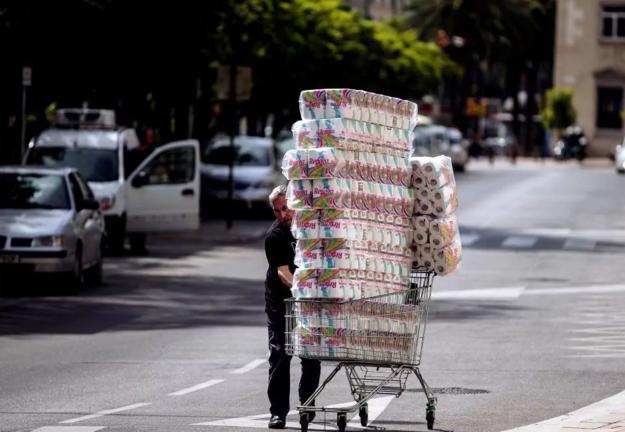 Un consumidor sale de una tienda con un carro lleno de papel higiénico EFE