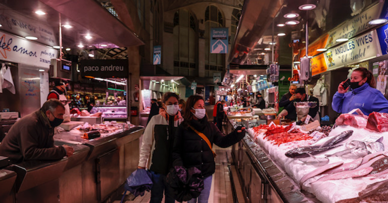 Dos personas pasan por un puesto de pescado en el Mercado Central de Valencia, a 24 de marzo de 2022, en Valencia, Comunidad Valenciana, (España). La Asociación de Supermercados de la Comunitat (ASUCOVA), la Asociación Valenciana de Consumidores y Usuarios (AVACU) y Mercavalència descartan que haya riesgo de desabastecimiento de productos por la huelga de transportistas, aunqu