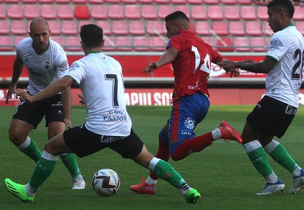 El delantero del Numancia Moha Sanhaji (2-d) trata de jugar un balón ante Alfon González (2-i), del Racing de Santander, durante el partido amistoso disputado este miércoles en Soria. Efe/Wifredo García
