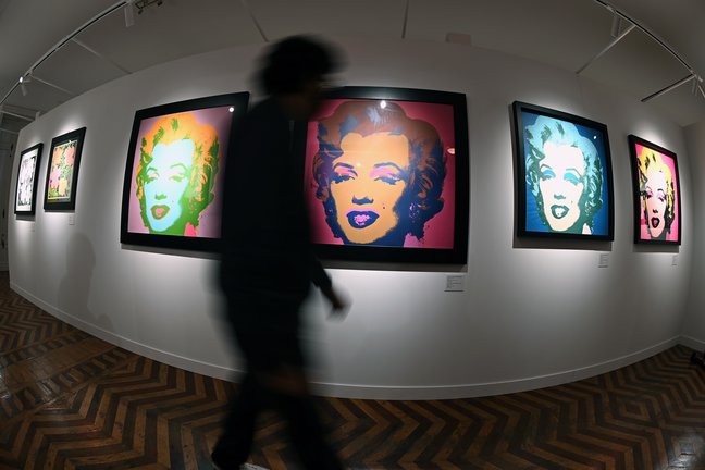 Un visitante pasa junta a varios retratos de Marilyn Monroe del artista estadounidense Andy Warhol. / Fernando Villar