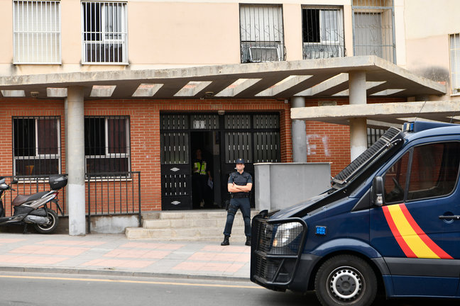 Un agente de la Policía Nacional frente a una vivienda que registraban. / AEE