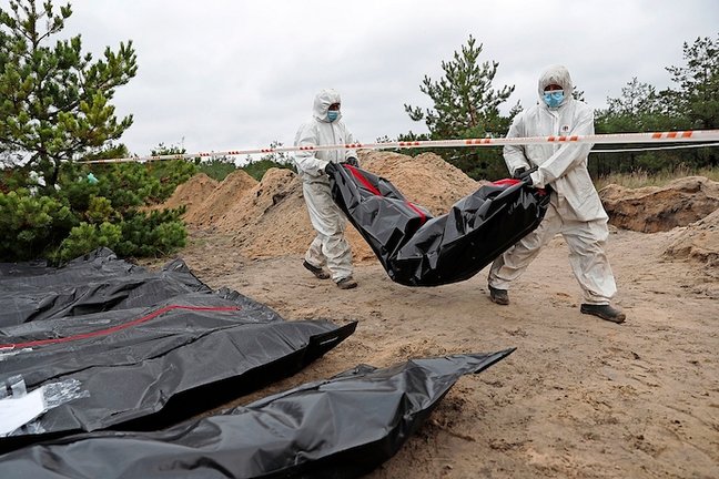 Técnicos forenses trabajan en un lugar de entierro en la ciudad recientemente recuperada de Lyman, en el área de Donetsk, en Ucrania, este 11 de octubre. EFE/EPA/ATEF SAFADI
