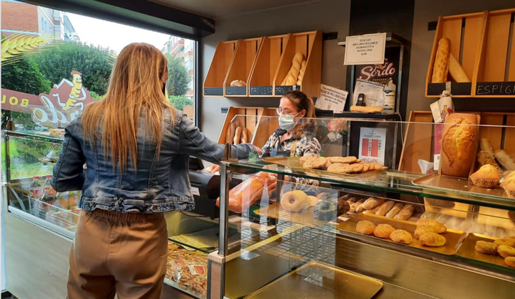 Una mujer compra en la panadería Sordo de Torrelavega. / ALERTA