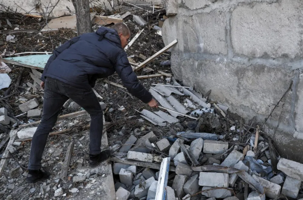 Un ucraniano inspecciona con una barra los escombros de un edificio destruido en la ciudad de Kupiansk, recientemente recuperada, al este de Kharkiv. EFE/EPA/Atef Safadi