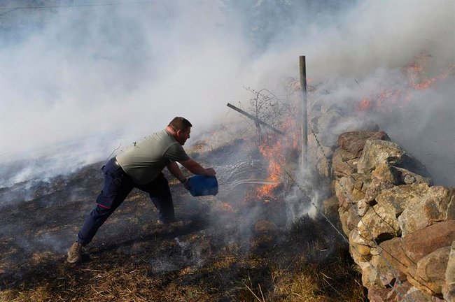 Vecinos de Bostronizo luchan contra el incendio forestal, declarado este sábado, en los montes de esta localidad Cántabra. EFE/Pedro Puente Hoyos