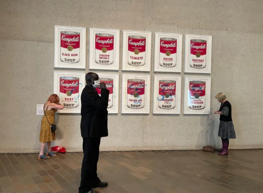 "Latas de sopa Campbell" del artista estadounidense Andy Warhol, atacada por activistas en la Galería Nacional de Camberra (Australia). EFE/ Stop Fossil Fuel Subsidies