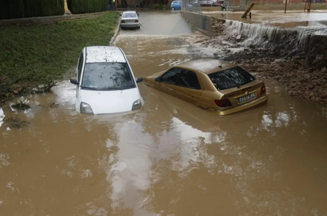 Dos coches semisumergidos en un paso inundado en Aldaia. EFE/ Kai Forsterling