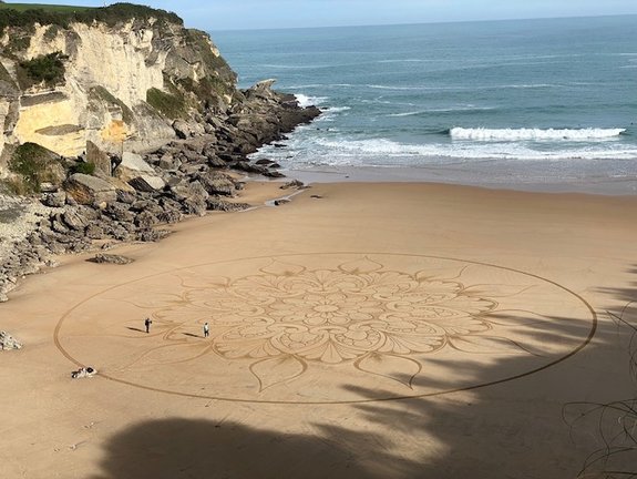 Cientos de personas han asistido hoy en la Playa de Mataleñas a la consecución del dibujo del mandala más grande del mundo.