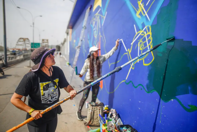 Araceli Villarreal y Meki pintan unos de los murales ubicado en la Avenida Alfonso Ugarte, en Lima (Perú). EFE/ Aldair Mejia