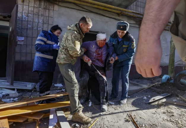 Varias personas ayudan a un hombre herido después de que un cohete impactara en un edificio residencial en Donetsk, Ucrania. EFE/EPA/Sergei Ilnitsky