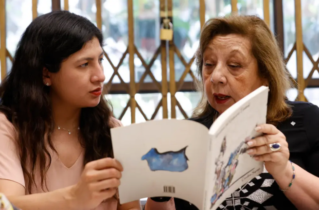 Vitoria Quiroz (d) y María José Zapata (i) participan en un club de lectura, el 30 de noviembre 2022, en la llamada Biblioteca de las Mujeres, en Santiago (Chile). EFE/ Elvis González