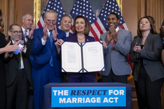 La presidenta de la Cámara de Representantes, Nancy Pelosi (c), sostiene el proyecto de 'Ley de respeto por el matrimonio' en el Capitolio, en Washington. EFE/EPA/Michael Reynolds