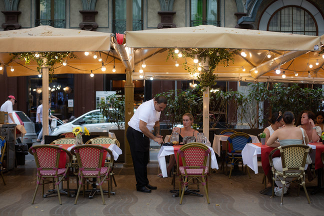 Un camarero atiende a una mesa en las Ramblas. / David Zorrakino