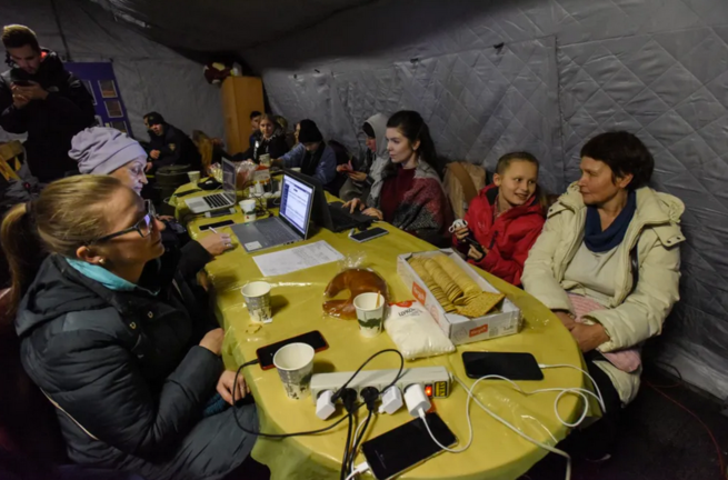 Ucranianos comparten una mesa en un punto de calefacción en Kiev. EFE/EPA/Oleg Petrasyuk