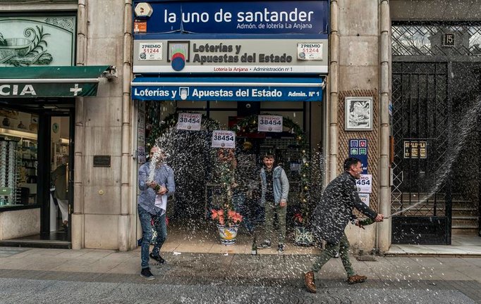 Varios agraciados celebran en la administración 'La Anjana' de Santander, donde este jueves se ha vendido un cuarto y un quinto premio de la Lotería de Navidad 2022. EFE/ Román G. Aguilera
