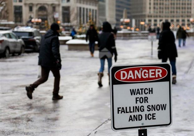La gente se abriga contra las temperaturas bajo cero y la nieve que sopla en Chicago, Illinois, EE.UU., 23 de diciembre de 2022. Gran parte de los EE.UU. está sintiendo los efectos de una tormenta de invierno como un frente frío ártico traer temperaturas bajo cero, nieve y hielo a gran parte de los EE.UU.. (Estados Unidos) EFE/EPA/TANNEN MAURY