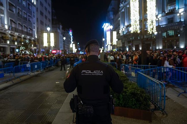 Un policía presta guardia en una calle que reúne a decenas de ciudadanos. EFE / Daniel González