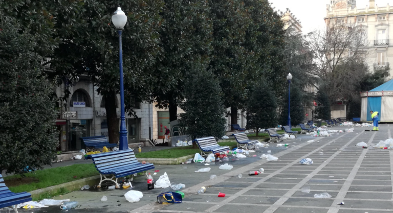 Los jóvenes más noctámbulos apuran las últimas horas de la Nochevieja, entre bolsas de basura y restos de botellón, en la Plaza de Pombo. / ALERTA