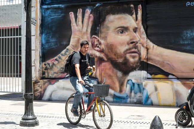 Un hombre en bicicleta pasa frente a un mural dedicado a Lionel Messi, en Buenos Aires (Argentina). EFE / Juan Ignacio Roncoroni