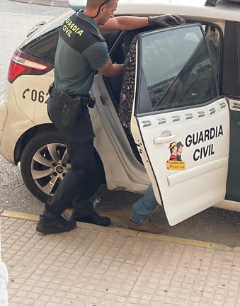 Un guardia civil introduce en el coche a un detenido. E.P.