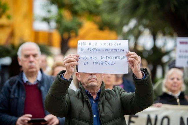 Un hombre muestra un cartel durante la concentración a las puertas del Ayuntamiento de El Puerto de Santa María (Cádiz) en repulsa por el asesinato de una mujer. EFE / Román Ríos