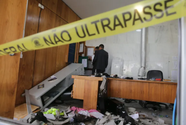 Dos hombres revisan una oficina destrozada al interior del Palacio de Planalto luego de que manifestantes bolsonaristas invadieran edificios gubernamentales en Brasilia (Brasil). EFE/André Coelho