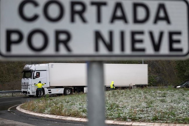 Guardias Civiles impiden el paso a camiones hacia la A-67, este miércoles, a la altura de la localidad cántabra de Arenas de Iguña por la nieve. EFE/ Pedro Puente Hoyos
