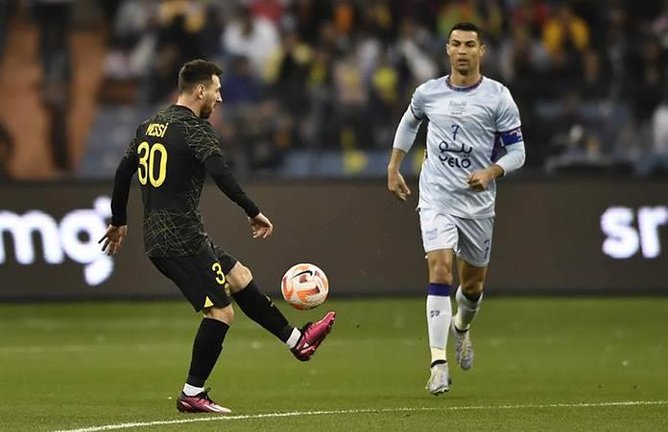 Leo Messi controla el balón ante la mirada de Cristiano Ronaldo.