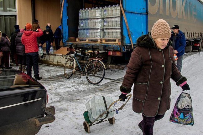 Una mujer recoge agua que se entrega de manera gratuita a los residentes de Oleksandro-Kalynove, en el este de Ucrania. / SERGEY KOZLOV