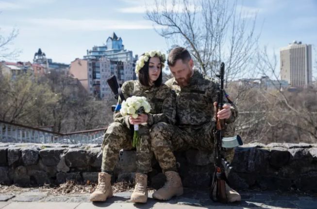 Dos miembros de las Fuerzas de Defensa Territorial de Kiev celebran su boda. EFE/Mikhail Palinchak