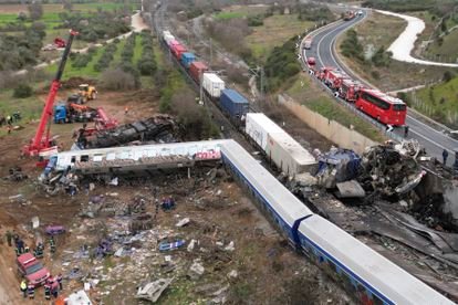 A crane, firefighters and rescuers operate after a collision in Tempe near Larissa city, Greece, Wednesday, March 1, 2023. A train carrying hundreds of passengers has collided with an oncoming freight train in northern Greece, killing and injuring dozens passengers. (AP Photo/Vaggelis Kousioras)