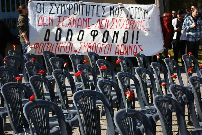 57 sillas colocadas por activistas fuera del Ministerio de Transporte conmemoran a las 57 víctimas del accidente de tren más mortífero de Grecia, en Atenas este lunes. EFE/EPA/ORESTIS PANAGIOTOU